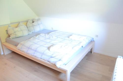 a white bed in a room with a white wall at Beautiful apartment in Treuchtlingen