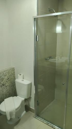 a bathroom with a toilet and a glass shower at GoldMen Express Cianorte in Cianorte