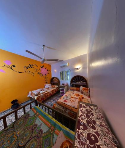 a bedroom with two beds and a ceiling at Nubian Kingdom Aragheed House in Aswan
