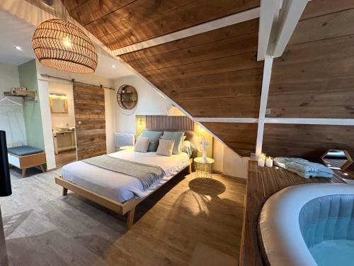 a bedroom with a bed and a tub in a room at Escale en Avesnois in Croix-Caluyau
