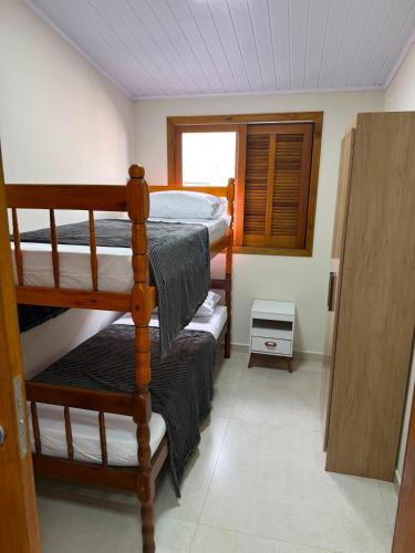 a room with two bunk beds and a window at Casa de lagoa in Laguna