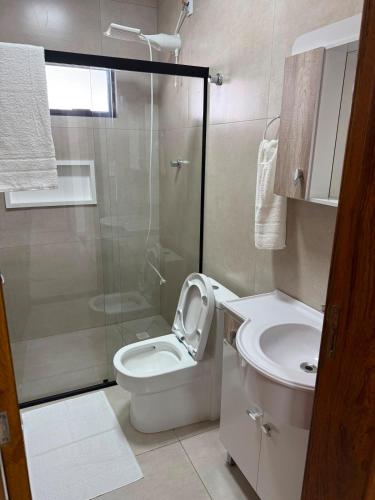 a bathroom with a shower and a toilet and a sink at Casa de lagoa in Laguna