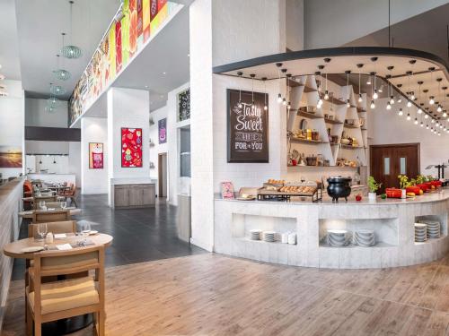 a restaurant with a counter with food on it at Ibis Styles Dragon Mart Dubai in Dubai