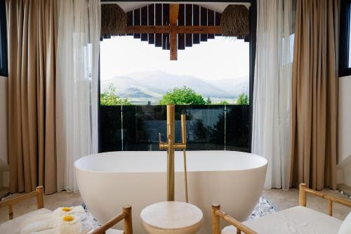 a bath tub in a bathroom with a large window at Namus House in Stepʼanavan
