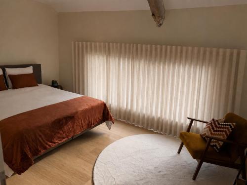 a bedroom with a bed and a window with curtains at Kerbault Suites - Martelange in Martelange