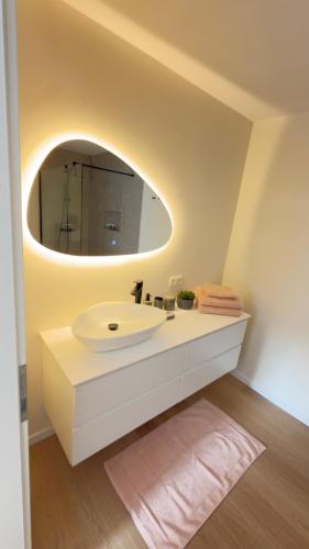 a bathroom with a white sink and a mirror at Kerbault Suites - Martelange in Martelange