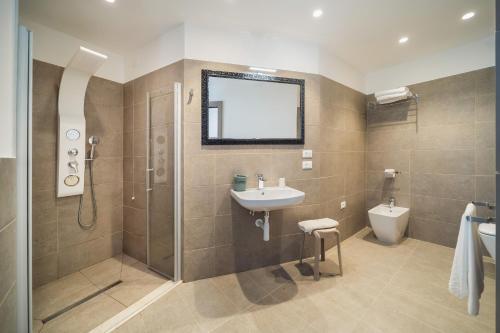 a bathroom with a sink and a shower and a toilet at Hotel Palladio in Caorle