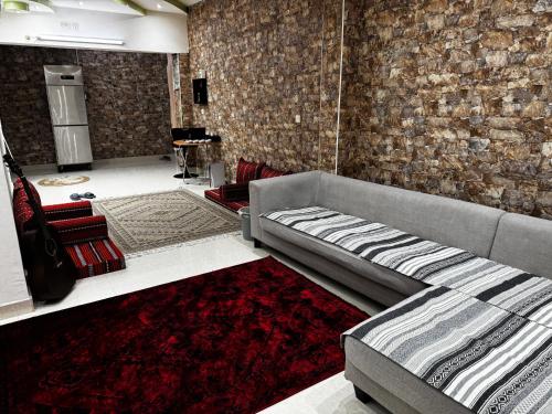 a living room with a couch and a brick wall at Dar Shaden hostel in Muscat