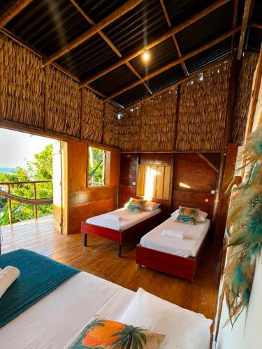 a bedroom with two beds and a balcony at DuMangue Kite House in Guriú