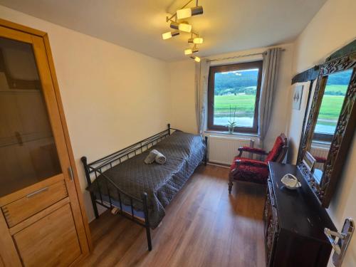 a bedroom with a bed and a couch and a window at Haus an der Weser in Oedelsheim