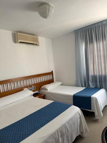 a hotel room with two beds and a window at Plaça Vella in Sant Carles de la Ràpita