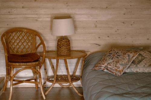 a bedroom with a bed and a table with a lamp and a chair at Domek na wyłączność w Otulinie Ojcowskiego Parku Narodowego in Wola Kalinowska