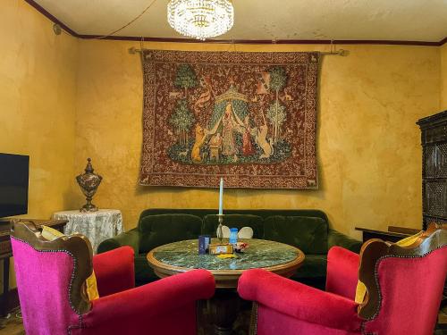 a living room with a table and red chairs at La Maison Bleue - Historic House in the Heart of Riquewihr in Riquewihr