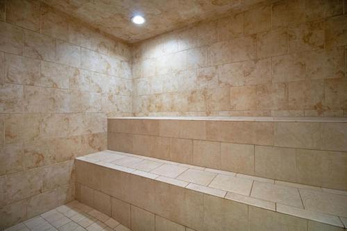a bathroom with a large shower with a stone wall at Massanutten Resort by TripForth in McGaheysville