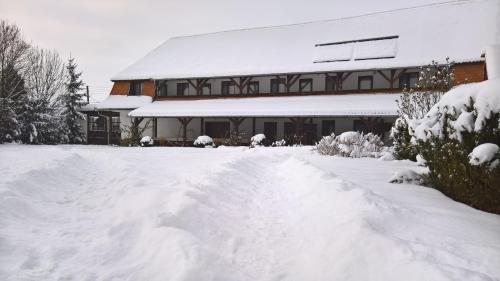 a house with a pile of snow in front of it at Kúria Vendégház in Cristuru Secuiesc