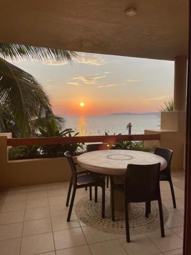 a table and chairs on a balcony with a view of the ocean at Tranquilidad Total Frente al Mar I 3 Hab y Alberca in Barra de Potosi