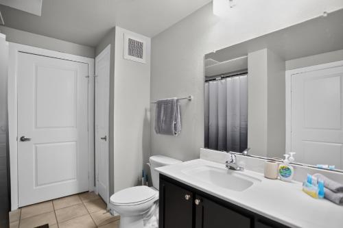 a bathroom with a sink and a toilet and a mirror at Spacious 1-bedroom apartment with modern comforts in Dallas