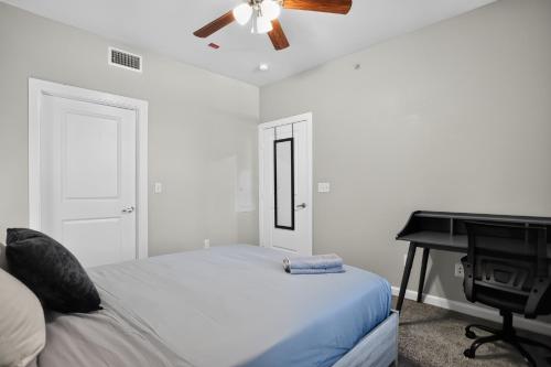 a white bedroom with a bed and a piano at Spacious 1-bedroom apartment with modern comforts in Dallas