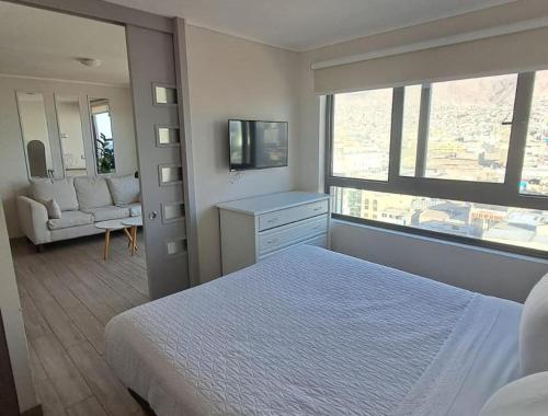 a bedroom with a bed and a living room at VIP Suite Antofagasta in Antofagasta
