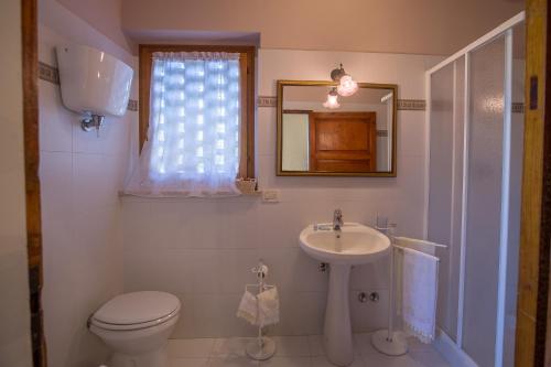 ein Badezimmer mit Toilette, Waschbecken und Spiegel in der Unterkunft Agriturismo La Manonera in Montepulciano
