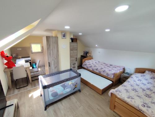 a small bedroom with two beds and a desk at Apartmani KOSMOS in Rudnik