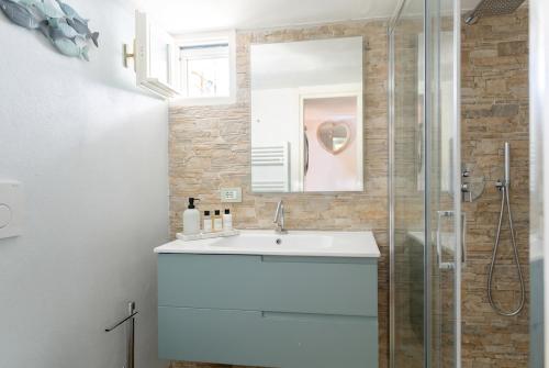 a bathroom with a sink and a glass shower at Villa with Pool e Jacuzzi Free Parking AC in San Lorenzo della Costa