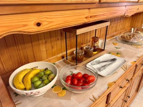 a counter with bowls of fruits and vegetables on it at Podere Cafasso Country House in Paestum
