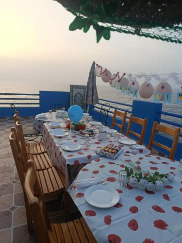a long table with plates of food on the beach at Goldenbeachhouse in Mirleft