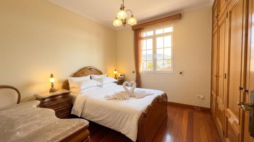 a bedroom with a bed with a ribbon on it at Vila Boehémia in Canhas