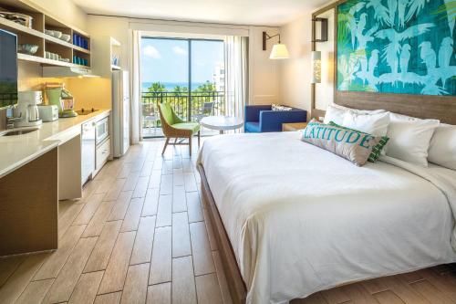 a hotel room with a large bed and a kitchen at Margaritaville Vacation Club - Rio Mar in Rio Grande