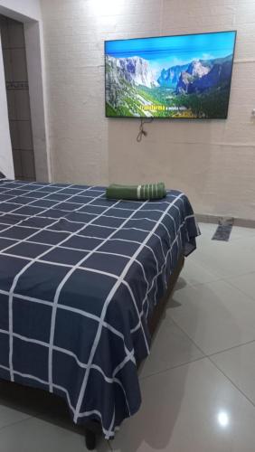 a bedroom with a bed and a flat screen tv on the wall at suite Perto do aeroporto de guarulhosAv Jovita 401 in Guarulhos