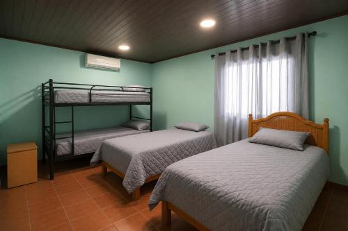 two bunk beds in a room with green walls at Villa Edallys in Capira