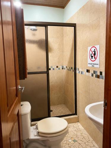 a bathroom with a shower with a toilet and a sink at Villa Edallys in Capira