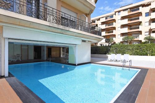 a large swimming pool in front of a building at Victoria Palace Elegant Apt with Terrace in Menton