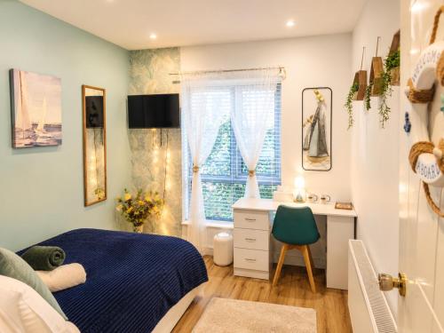 a bedroom with a bed and a desk and a window at Galway Paradisus in Galway
