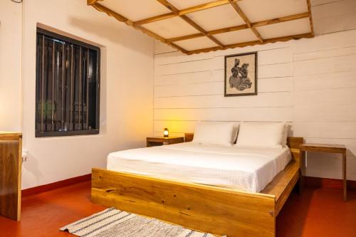 a bedroom with a bed and a window at Don Padris Estate Bungalow in Tangalle
