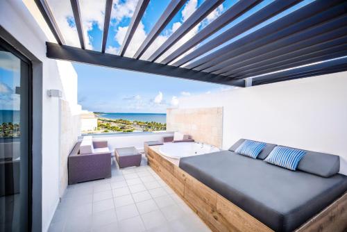 a bedroom with a bed and a view of the ocean at Majestic Elegance Costa Mujeres - All Inclusive in Cancún