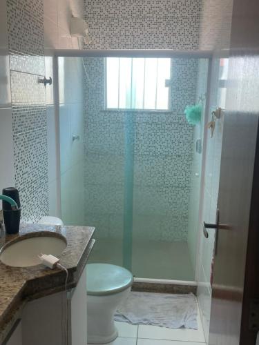 a bathroom with a shower with a toilet and a sink at Casa em Maricá- Paraiso Itaipuaçu in Maricá