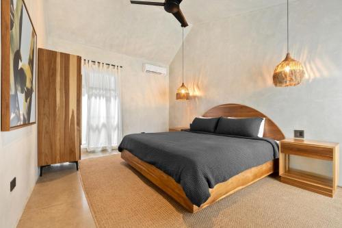 a bedroom with a bed and a ceiling fan at Selvatico Tamarindo Villas in Tamarindo