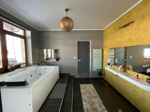 a large bathroom with a large tub and two sinks at Panorama Lake Resort in Bezidu Nou