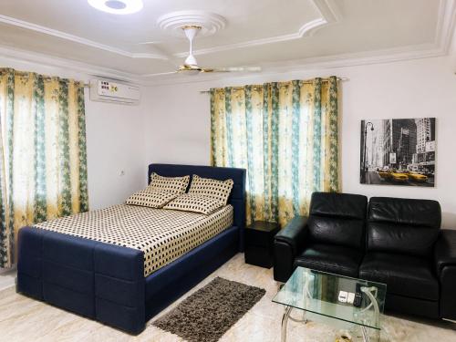 a bedroom with a bed and a couch at Big Papa Hotel in Amasaman