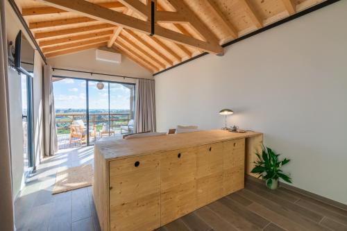 an office with a wooden desk in a room with a large window at Eira das Maçãs - Óbidos 
