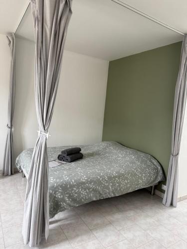 a bedroom with a bed with a canopy and curtains at Chez Ben et Lou in Envermeu