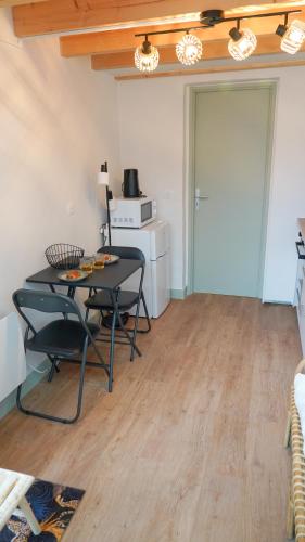 a room with a table and chairs and a kitchen at Le Perchoir d'Orthez in Orthez