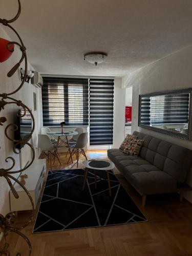 a living room with a couch and a table at Capital apartman in Visoko