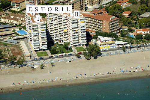 Una playa con un montón de sombrillas. en Apartamentos Estoril I - II Orangecosta, en Benicàssim