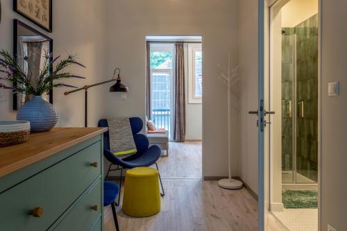 a bathroom with a counter and a yellow stool in a room at Piccoleto Bianco in Badacsonytomaj