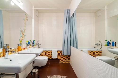 a bathroom with two sinks and a tub and two toilets at Horyzont in Gdańsk