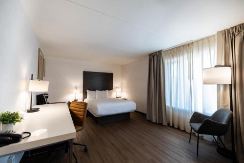 a hotel room with a bed and a desk at The Atlas° Hotel in Regina