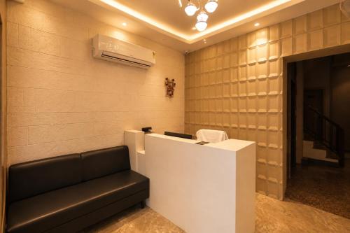 a waiting room with a black couch and a heater at Hotel River Front in Kota